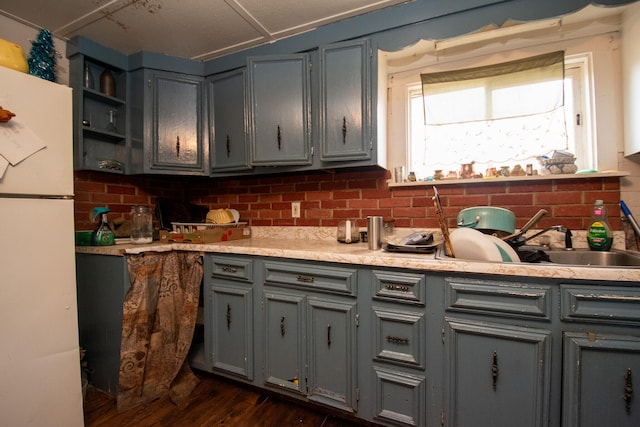 kitchen with gray cabinetry, sink, tasteful backsplash, dark hardwood / wood-style flooring, and white refrigerator