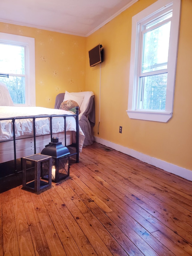 599 Plains Rd, Hollis, ME 04042 - bedroom featuring wood-type flooring, ornamental molding, multiple windows, and baseboards