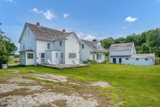 back of house featuring a lawn and a deck