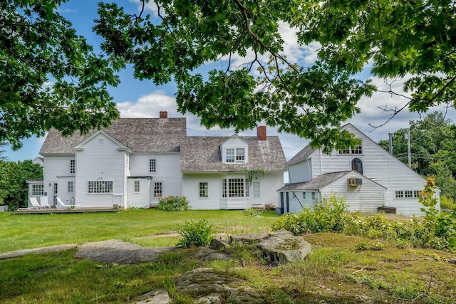 back of house featuring a lawn and a wooden deck