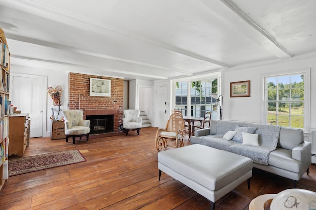 living room featuring hardwood / wood-style flooring, beamed ceiling, and a brick fireplace