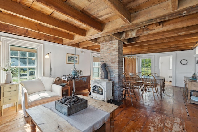 living room with wooden ceiling, dark hardwood / wood-style floors, a wood stove, and a healthy amount of sunlight