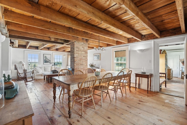 dining space with beamed ceiling, light hardwood / wood-style floors, and a wealth of natural light