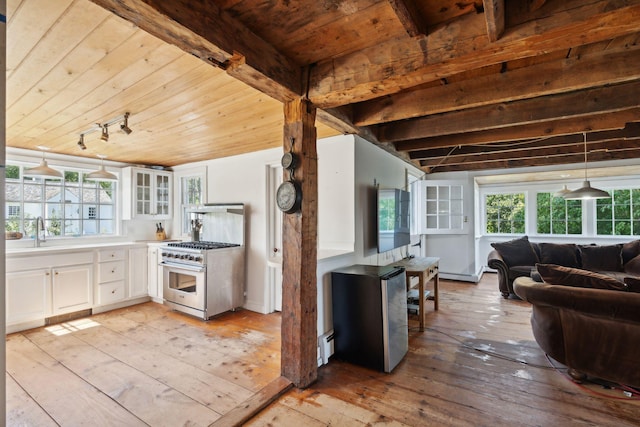 kitchen featuring stainless steel stove, white cabinetry, baseboard heating, and light hardwood / wood-style floors