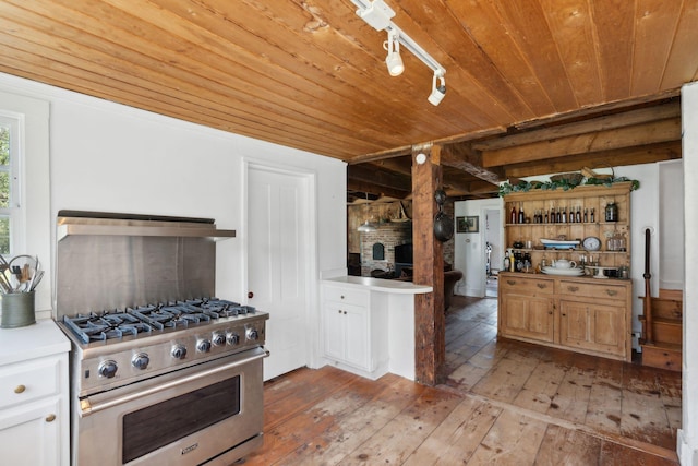 kitchen with wall chimney exhaust hood, wooden ceiling, high end stove, light hardwood / wood-style floors, and white cabinets