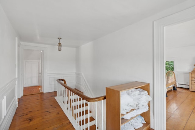 corridor with light wood-type flooring and a baseboard radiator