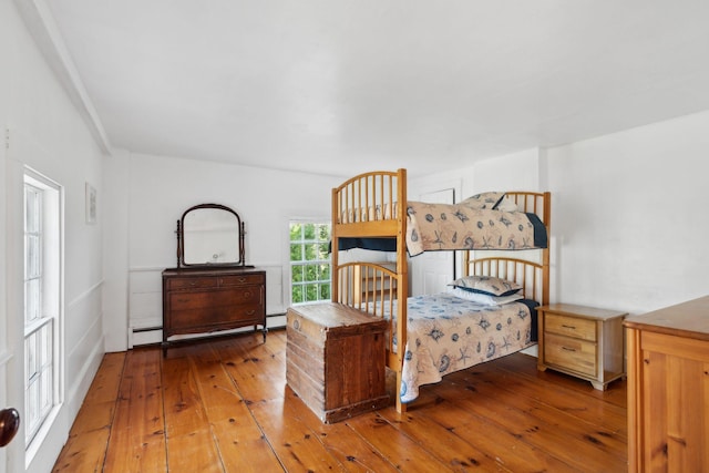 bedroom featuring baseboard heating and wood-type flooring