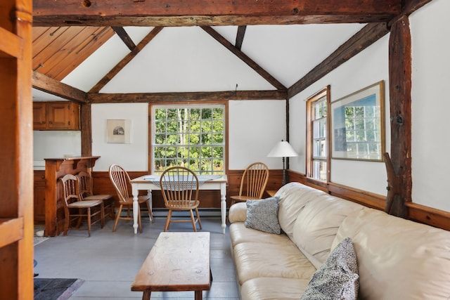 living room with beam ceiling, wood walls, and high vaulted ceiling