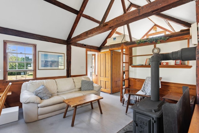 living room with beam ceiling, a wood stove, and high vaulted ceiling