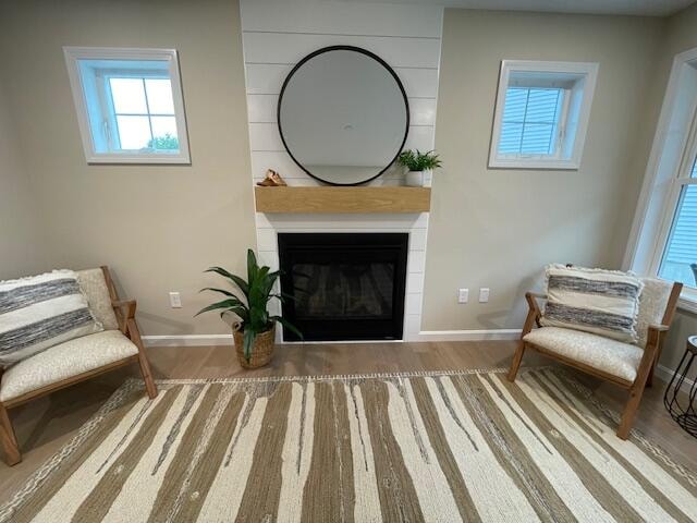 sitting room featuring a large fireplace and hardwood / wood-style floors