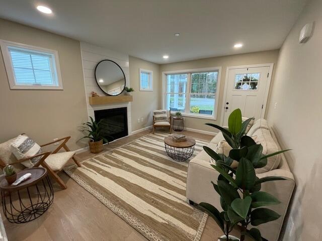 living area with a fireplace and light hardwood / wood-style flooring