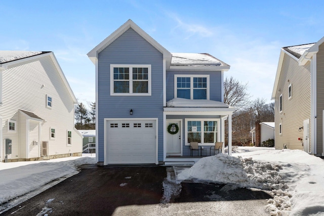 traditional-style home with a garage, driveway, and covered porch