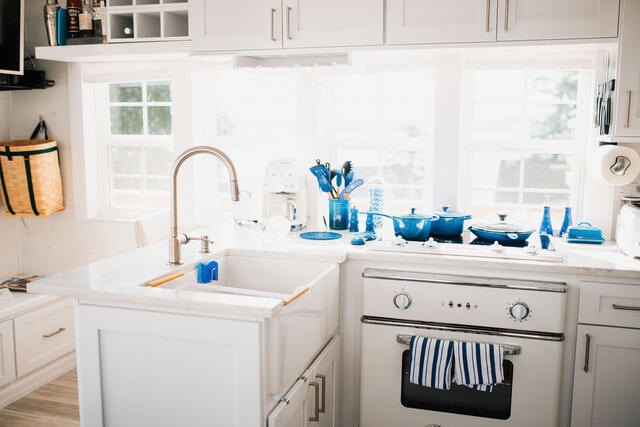 kitchen featuring white appliances, light countertops, a sink, and white cabinetry