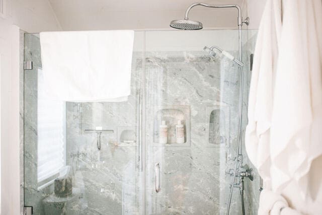 bathroom featuring a marble finish shower