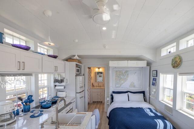 bedroom featuring lofted ceiling, light wood-style floors, and a sink