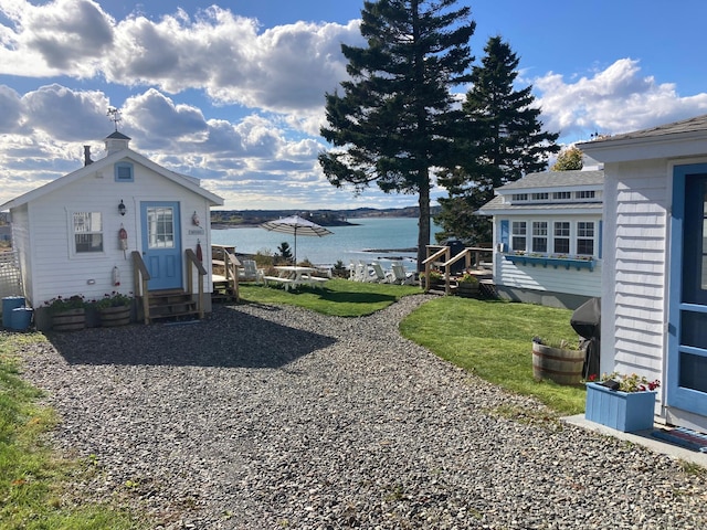 view of yard with entry steps and a water view