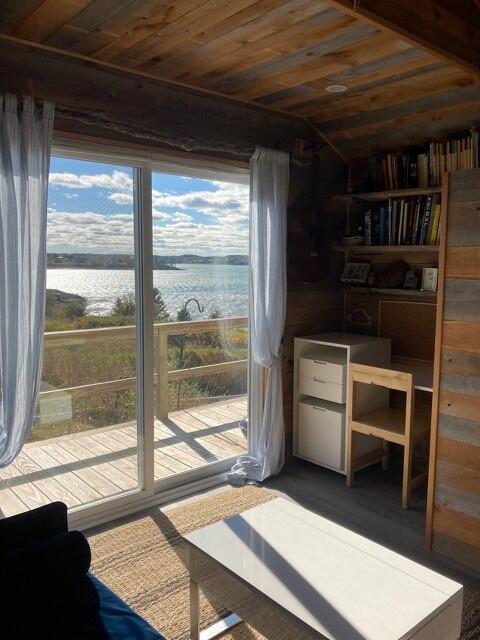 doorway to outside featuring a water view, wooden ceiling, vaulted ceiling, and a wealth of natural light