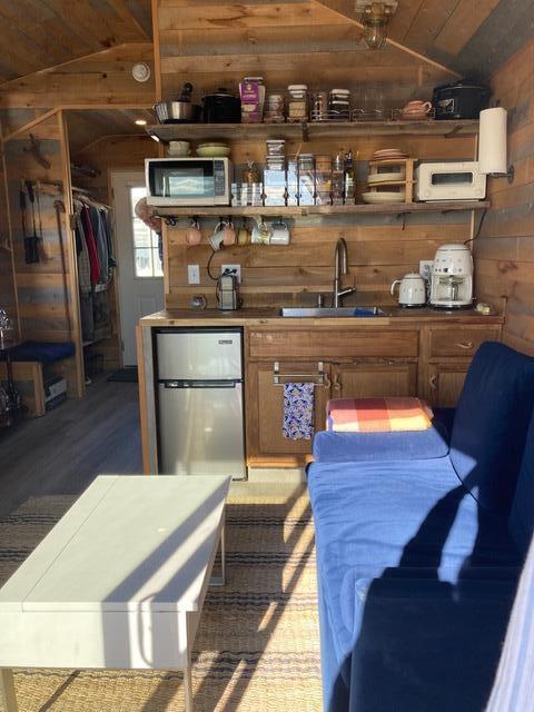 16 Monument St, Lubec, ME 04652 - bar featuring appliances with stainless steel finishes, wooden walls, lofted ceiling, wood finished floors, and wooden ceiling
