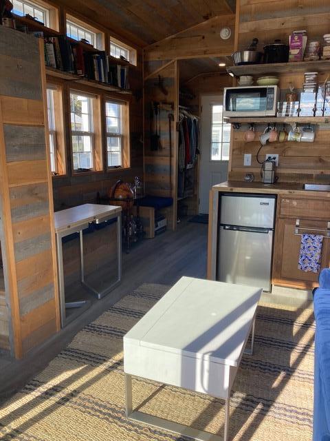 kitchen featuring vaulted ceiling, wooden ceiling, freestanding refrigerator, and wooden walls