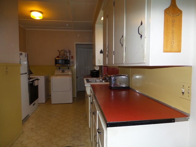 kitchen with white cabinets, white fridge, sink, and washer / clothes dryer