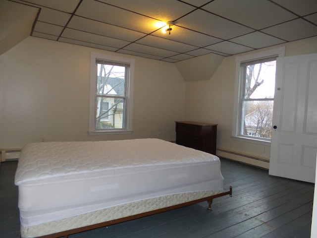 bedroom featuring a drop ceiling, a baseboard radiator, multiple windows, and dark wood-type flooring