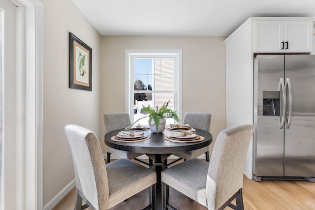 dining room with light wood-style flooring and baseboards