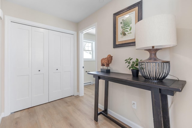 entryway featuring light wood-type flooring and a baseboard heating unit