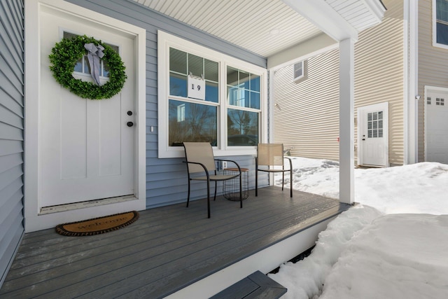 wooden deck featuring covered porch and a garage