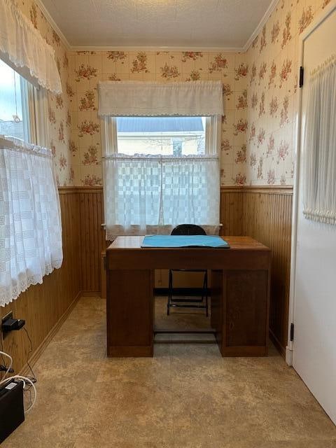 office space with ornamental molding, a textured ceiling, and wooden walls