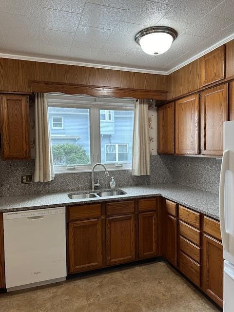 kitchen featuring decorative backsplash, sink, white appliances, and ornamental molding