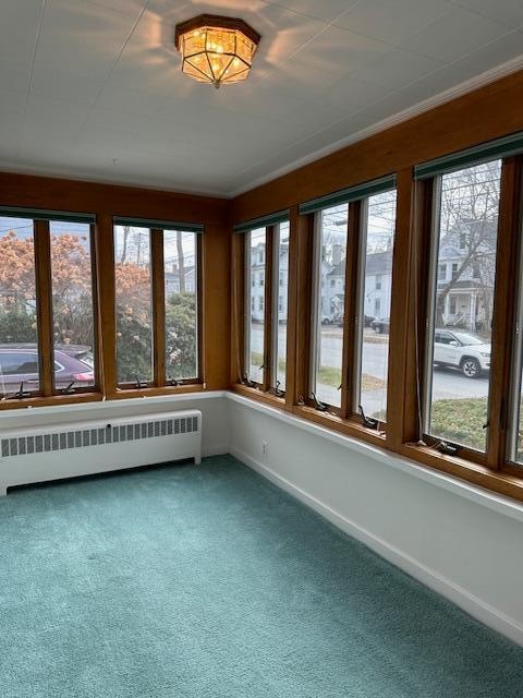 unfurnished sunroom with radiator and plenty of natural light