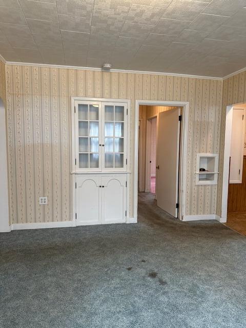 carpeted empty room featuring crown molding