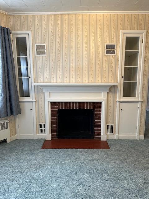 unfurnished living room featuring a fireplace, carpet, and radiator heating unit