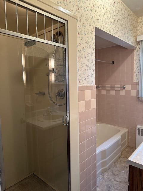 bathroom featuring separate shower and tub, radiator heating unit, and vanity