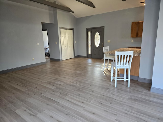 interior space featuring vaulted ceiling with beams, ceiling fan, and light wood-type flooring