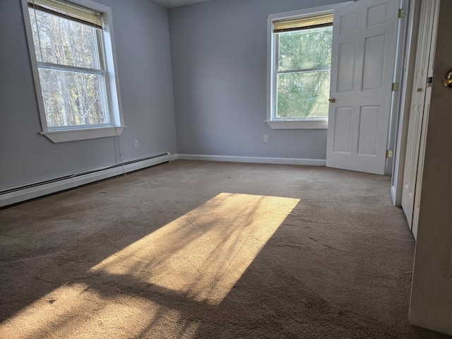 spare room featuring light carpet, a baseboard radiator, and a wealth of natural light