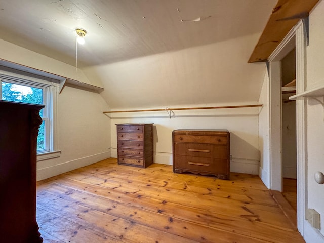 spacious closet featuring light hardwood / wood-style flooring and vaulted ceiling