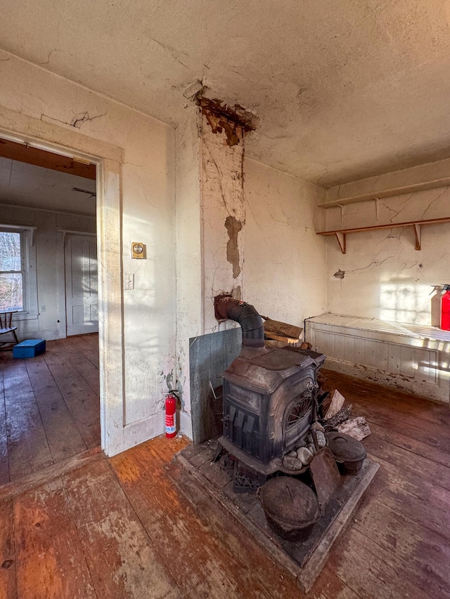 details with a wood stove and wood-type flooring