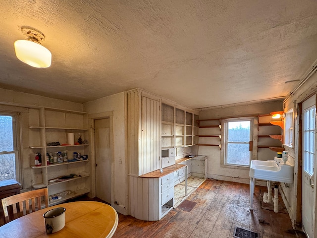 kitchen featuring butcher block countertops, sink, a textured ceiling, and hardwood / wood-style flooring