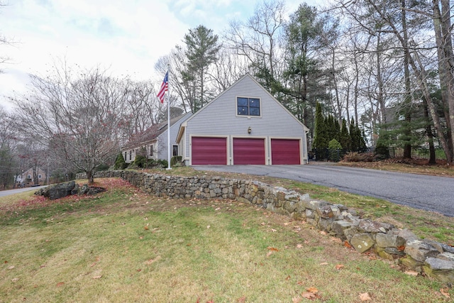 view of side of property with a garage and a lawn