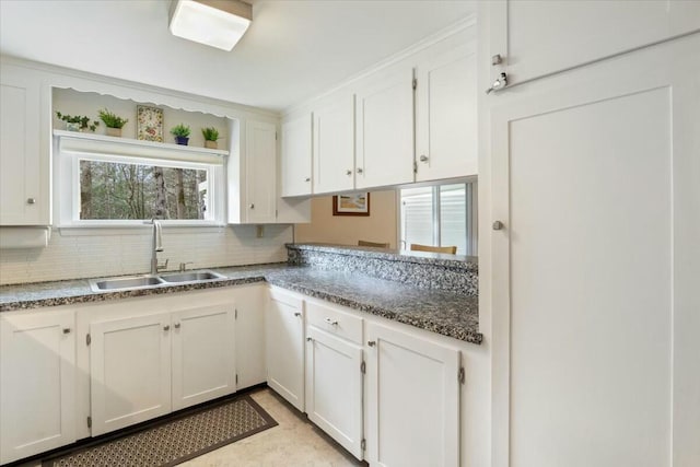 kitchen with white cabinets, decorative backsplash, a wealth of natural light, and sink