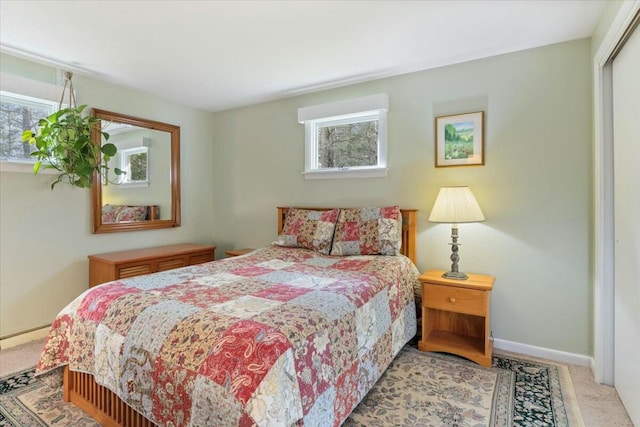 carpeted bedroom featuring multiple windows and a closet