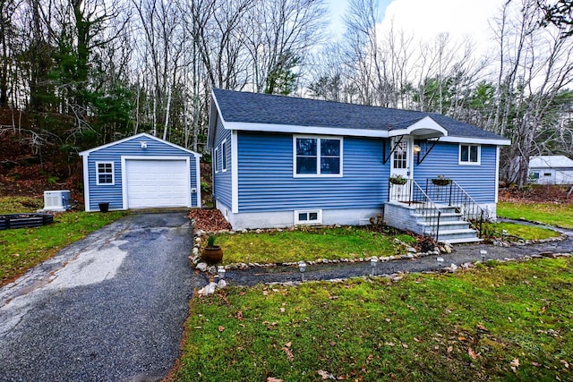 view of front of home featuring driveway, a garage, roof with shingles, an outdoor structure, and a front lawn