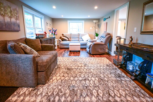 living area with baseboards, wood finished floors, and recessed lighting