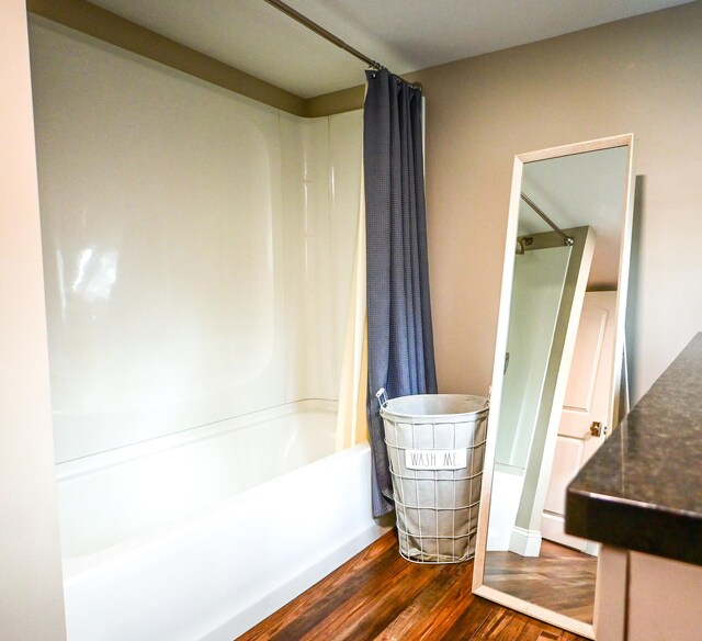 full bathroom featuring shower / bath combo and wood finished floors