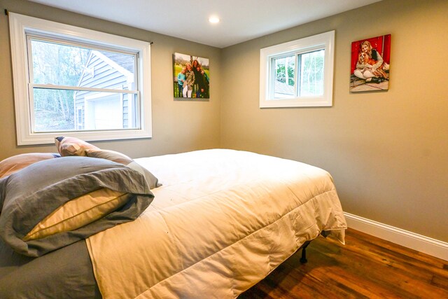 bedroom featuring baseboards, wood finished floors, and recessed lighting