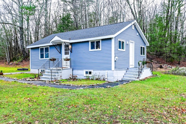 view of front of home featuring a shingled roof and a front yard