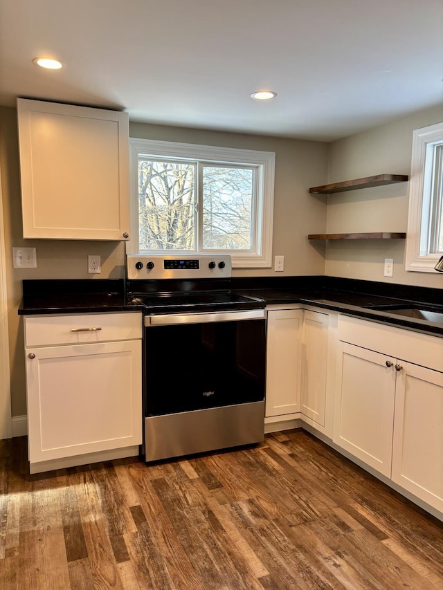 kitchen with electric range, white cabinetry, dark wood-type flooring, and a sink