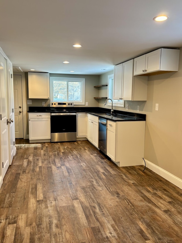 kitchen with baseboards, appliances with stainless steel finishes, open shelves, dark countertops, and dark wood finished floors