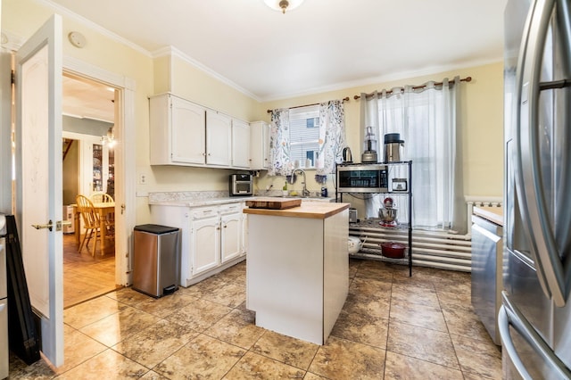 363 Broadway, Bangor, ME 04401 - kitchen featuring freestanding refrigerator, white cabinetry, crown molding, butcher block countertops, and a center island